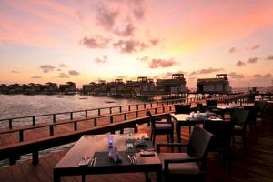 Sonnenuntergang mit Blick auf das Angsana Velavaru Resort und Wasservillen.