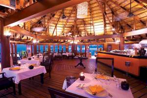 Innenansicht des Restaurants im Angsana Velavaru mit Blick auf das Meer und gedeckten Tischen.