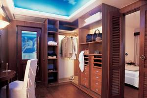 Kleiderschrank in einem Zimmer des Elounda Bay Palace Hotels mit vielen Regalen und Schubladen.