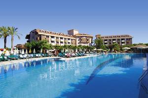 Außenbereich des Primasol Hane Family Resort mit großem Swimmingpool und Sonnenliegen.