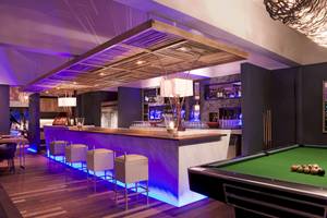 Hotelbar des Taj Coral Reef Resort & Spa mit Bartheke, Sitzgelegenheiten, Pooltisch und Beleuchtung