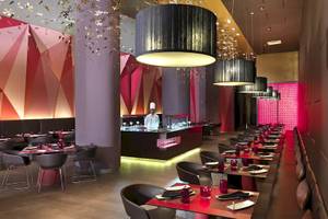 Innenansicht des Restaurants im Paradisus Playa del Carmen mit modernem Design und einem Koch am Tresen.