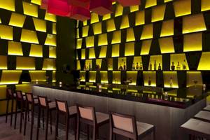 Innenansicht der Bar im Paradisus Playa del Carmen Hotel mit gelben Wandverkleidungen und Theke.