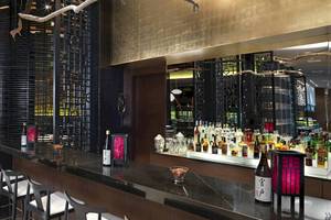 Innenansicht der Bar im Paradisus Playa del Carmen Hotel mit Tresen, Stühlen und vielen Getränkeflaschen.