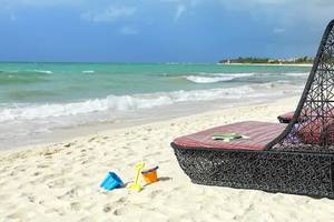 Strandszene mit schwarzen Strandliegen und Spielzeug am Paradisus Playa del Carmen
