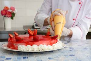 Koch dekoriert Kuchen mit Erdbeeren und Sahne im Paradise Hotel Corfu