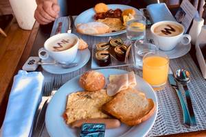 Frühstücksbuffet im Sofitel Mauritius L'Imperial Resort & Spa mit Kaffee, Orangensaft, Brot, Eiern und weiteren Speisen.