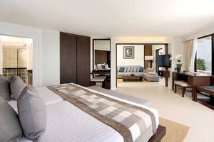 Schlafzimmer im Cape Panwa Hotel mit Doppelbett, Fernseher und Wohnzimmer.