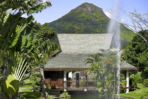 Außenansicht des Sofitel Mauritius L'Imperial Resorts & Spa mit einem Brunnen und grüner Landschaft