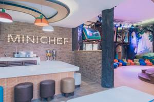 Innenbereich des Iberostar Paraiso del Mar Mini Chef Bereich mit gemauerter Wand, Bar, Stühlen und bunter Bemalung.