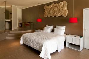Schlafzimmer im Fisherman's Cove Resort mit Doppelbett, weißen Kissen, roter Beleuchtung und Holzwanddekoration.