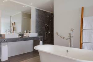 Badezimmer im Fisherman's Cove Resort mit Badewanne, Waschbecken und Handtüchern.