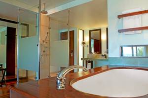 Badezimmer im Fisherman's Cove Resort mit Regendusche, Badewanne und Spiegeln.
