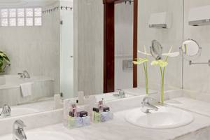 Badezimmer des H10 Playa Meloneras Palace Hotels mit Badewanne und Waschbecken.