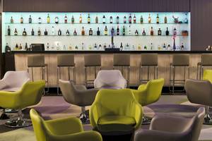 Innenansicht der Bar im H10 Playa Meloneras Palace mit vielen Getränkeflaschen und verschiedenen Stühlen.