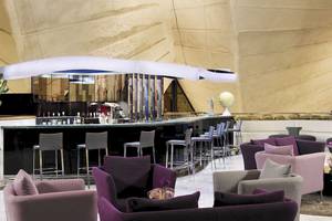 Loungebereich des H10 Playa Meloneras Palace mit einer Bar, Sitzgelegenheiten und Kakteen.
