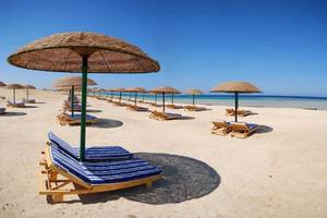 Strand mit Sonnenliegen und Sonnenhuten im Gorgonia Beach Resort