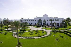 Luftaufnahme des Gorgonia Beach Resorts mit gepflegtem Garten und mehreren Palmen.