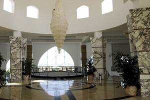 Foyer des Gorgonia Beach Resorts mit hohen Säulen, Kronleuchter und Pflanzen in Töpfen.
