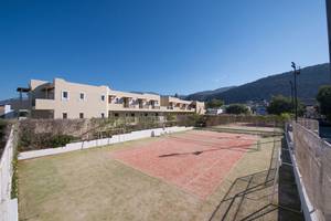 Tennisplatz des Alexander Beach Hotel & Village Resort mit umliegender Bebauung.
