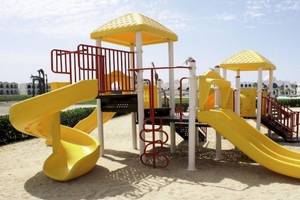 Kinderspielplatz im Gorgonia Beach Resort Hotel mit gelben Rutschen und roter Treppe.