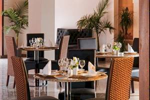 Restaurant des Pickalbatros Aqua Fun Club Hotels mit gedeckten Tischen und Pflanzen im Hintergrund.