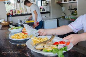 Essen im Malhun Hotel mit gebratenem Fisch, Pommes und Salat