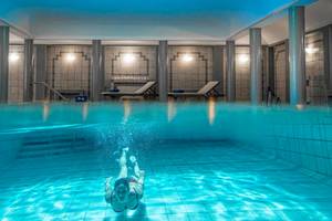 Eine Frau schwimmt im Innenpool des Bella Beach Hotels.