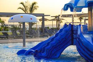 Blaue Wasserrutsche im Schwimmbad des Akti Imperial Deluxe Resort mit Wasserfontäne
