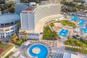 Luftaufnahme des Akti Imperial Deluxe Resort & Spa Dolce by Wyndham mit mehreren Swimmingpools und Sonnenliegen.