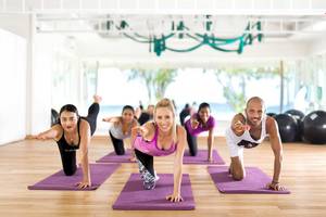 Gruppe von Menschen, die Yoga im Kandima Maldives Hotel machen