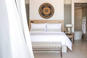 Hotelzimmer im Jumeirah at Saadiyat Island Resort mit Bett, Tisch, Lampe und Badezimmer