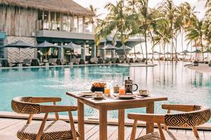 Frühstückstisch am Pool des Finolhu Baa Atoll Hotels auf den Malediven