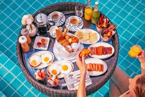 Frühstück am Pool im Finolhu Baa Atoll Maldives mit einer Auswahl an Speisen und Getränken.