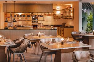 Innenansicht des Restaurants im Finolhu Baa Atoll Maldives mit modernen Esstischen und Stühlen.