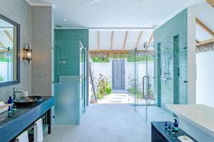 Badezimmer im Finolhu Baa Atoll Maldives Hotel mit blauen Fliesen und Glasdusche.