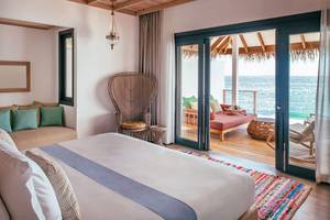 Schlafzimmer mit Meerblick im Finolhu Baa Atoll, Malediven, mit Bett, Möbeln und Meeraussicht.