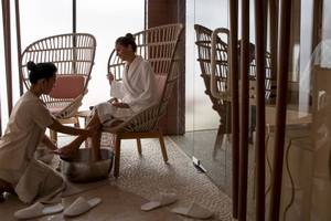 Spa-Behandlung im Jumeirah at Saadiyat Island Resort mit einer Frau, die sich die Füße waschen lässt.