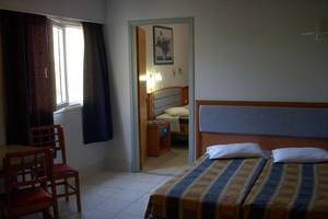 Doppelzimmer im Atlantis Beach Hotel in Kos mit zwei Betten, Tisch und Stühlen.