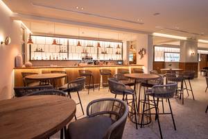 Barbereich im Horizon Beach Resort mit Holztischen, Stühlen und einer Bar.