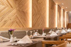 Innenansicht des Restaurants im Horizon Beach Resort mit gemusterten Holzwänden und gedeckten Tischen.
