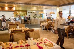 Innenansicht des Restaurants im Siva Grand Beach Hotel mit Gästen und serviertem Essen.