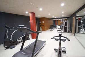 Fitnessbereich im Hotel Riviera Vista mit Laufband, Ellipsentrainer und Gewichtsbank.