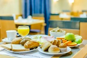 Frühstücksbuffet im Hotel Del Mar in Barcelona mit Brot, Obst und Getränken.