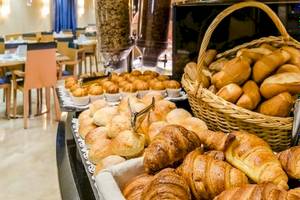 Frühstücksbuffet im Del Mar Hotel in Barcelona mit verschiedenen Brötchen und Croissants.