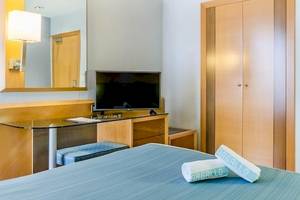 Hotelzimmer im Del Mar Hotel in Barcelona mit Fernseher, Schreibtisch und Schränken