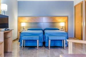 Hotelzimmer im Del Mar Barcelona mit zwei Betten, Nachttischen und Lampen