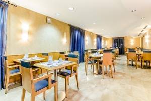 Restaurant im Del Mar - Barcelona Hotel mit gedeckten Tischen und Stühlen.