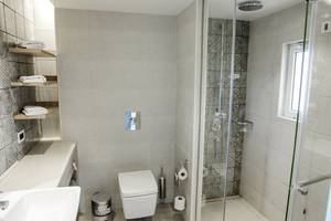 Badezimmer im Robinson Kyllini Beach Hotel mit Dusche, Toilette und Waschbecken.