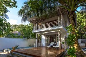 Villa des Amaya Kuda Rah Hotels mit Pool, Holzterrasse und Liegestühlen.